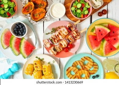 Summer BBQ or picnic food concept. Selection of fruits, salad, grilled meat and potatoes. Top view table scene over a white wood background. - Powered by Shutterstock