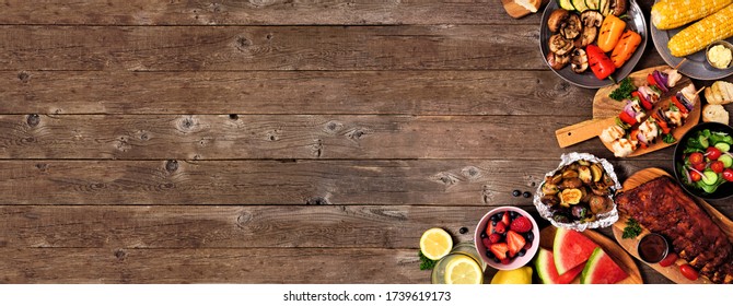 Summer BBQ Or Picnic Food Corner Border Over A Rustic Wood Banner Background. Assorted Grilled Meats, Vegetables, Fruits, Salad And Potatoes. Overhead View With Copy Space.