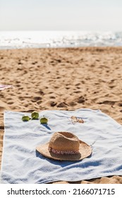 Summer beach accessories on sand background. Holiday travel, tropical concept. Straw hat, sunglasses, towel and fruits. Sun shadow and sunlight. - Shutterstock ID 2166071715