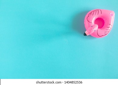 Summer beach composition. Inflatable mini flamingo on pastel blue background, pool float party, trendy summer concept. Flat lay, top view, copy space 