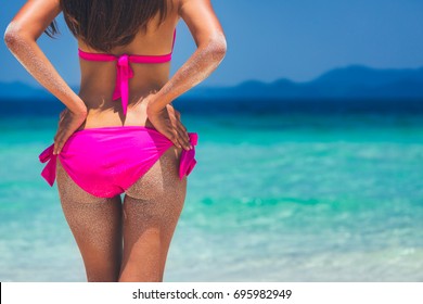 Summer beach concept. Sexy Pretty slim woman buttocks in pink swimwear bikini on blue sea with cloud and sky background at day, Phuket, Thailand