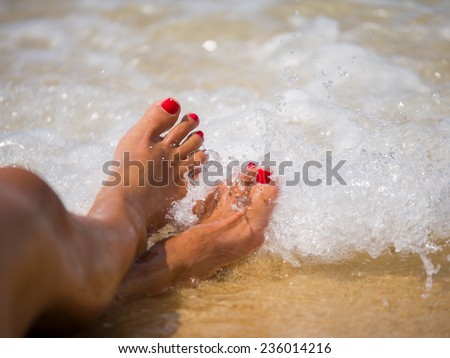 summer, beach, leisure and body part concept - closeup of woman feet on the beach