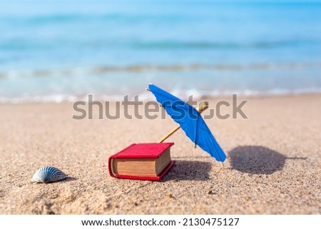 Summer beach nostalgia leisure objects in miniature: seashell, parasol and book (copy space) - Nostalgic Beach Holiday