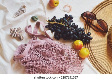 Summer Beach Picnic Aesthetics. Fishnet Bag, Black Grapes, Nectarines, Seashells, Hat And Sunglasses. Travel Flat Lay Photo