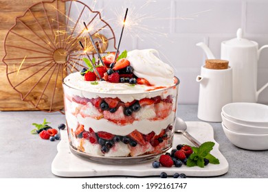 Sommerbeere rot, weiß und blau mit Engelkuchen in einer großen Schüssel. Dessert für 4. Juli, Unabhängigkeitstag süße Leckereien mit Sparklern