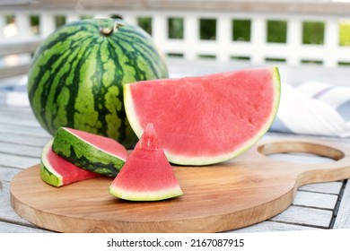 Summer berry, seedless watermelon and slices on a table on wooden terrace. - Shutterstock ID 2167087915