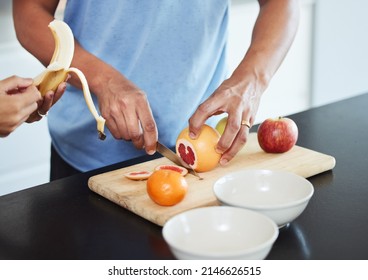 Summer is the best time for fruit. Shot of a couple peeling and cutting up fruit together. - Powered by Shutterstock