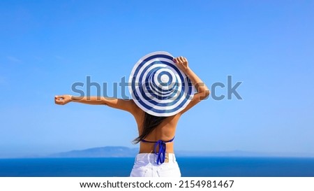 Summer blue trend with young woman wearing a hat as happy freedom lifestyle in Aegean sea mediterranean at Santorini,greece