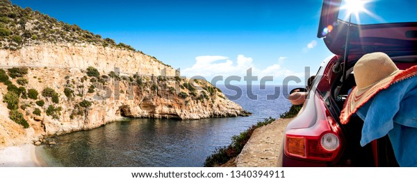 Summer car and landscape with sea\
and sun . Red car with suitcase. Free space for your text.\
