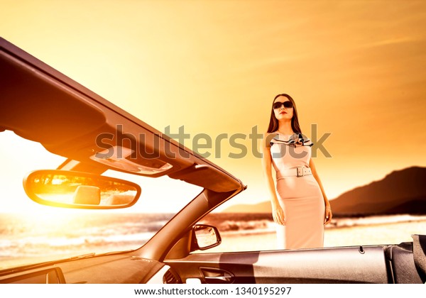 Summer car and slim young woman in\
dress. Free space for your decoration and sunset time.\
