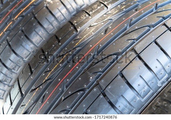 Summer car tire. Tire stack background.\
Car tyre protector close up view. Black rubber tire background. New\
car tires. Close up black tyre profile\
texture