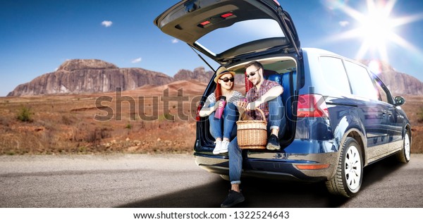 Summer
car trip on USA road and two oung lovers. Free space for your
decoration. Blue big car and summer sun light.
