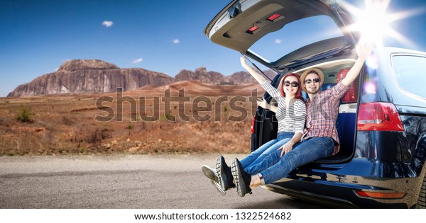 Summer\
car trip on USA road and two oung lovers. Free space for your\
decoration. Blue big car and summer sun light.\
