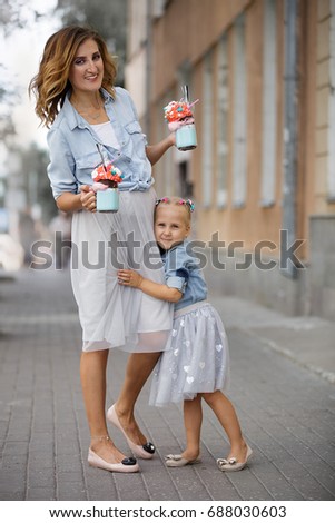 summer city walk of a mother and daughter with milkshakes in beautiful dresses