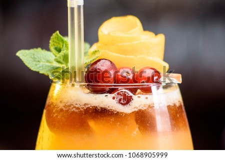 summer cocktail decorated with berries and mint on a bar counter on a floral background. close up