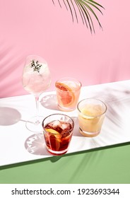 Summer cocktail with fruit and ice. Drink on white table over pink wall in sunlight with palm leaf shadow. Summer, tropical, fresh cocktail concept. - Shutterstock ID 1923693344