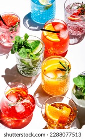 Summer cocktails drinks set. Assortment of multicolored strong and low alcoholic beverages for cocktail party. White background, hard light, shadows pattern, top view - Shutterstock ID 2288077513