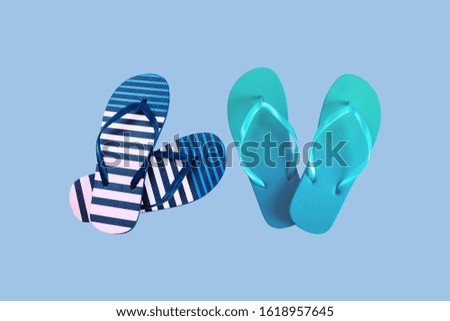 Summer colorful striped print flip flops isolated on blue background. Top view