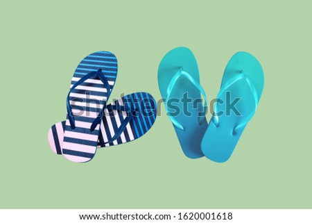 Summer colorful striped print flip flops isolated on green background. Top view