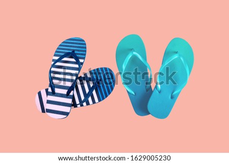 Summer colorful striped print flip flops isolated on coral background. Top view