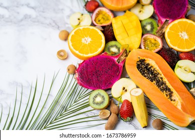 Summer Composition From Different Sliced Exotic Fruits And Tropical Leaves. Fresh Sliced Apple, Mango, Orange, Kiwi, Papaya, Maracuja, Dragon Fruit, Rambutan, Longan On Table. Healthy Food. Copy Space