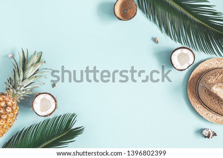 Summer composition. Tropical palm leaves, hat, fruits on blue background. Summer concept. Flat lay, top view, copy space