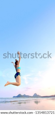 summer concept from asian woman in bikini is jumping on the beach with freedom for website where you place banner ads.