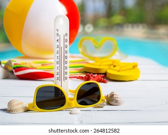 Summer Concept Of High Temperature, Flip Flop Shoes, Sunglasses On Pier Near Hotel Pool