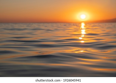 Summer concept: Relaxing sea view of a colorful and dramatic sunset or romantic sunrise reflecting over the sea with focus on water. Tranquility and peace. Meditation. Natural sky and sea background