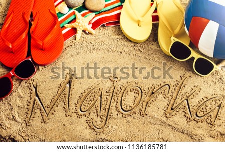Summer concept of sandy beach, colorful thongs shoes, sunglasses, ball and inscription majorka Zdjęcia stock © 