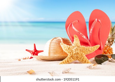 Summer Concept Of Sandy Beach, Straw Hat, Shells And Starfish.