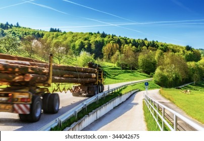 Summer Country Road And A Log Truck Transporting Timber. Scenic Forestry Background.