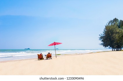 summer couple of Middle-aged 40-50year on the beach vacation holiday relax on their  chairs under a red umbrella.  travel concept at Hua Hin Prachuap Khiri Khan in Thailand.Shoot photo by smart phone - Powered by Shutterstock