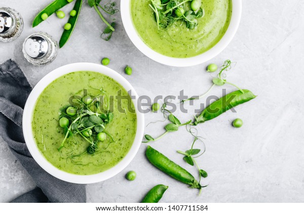 Summer\
cream soup with green fresh pea shoots. Top\
view