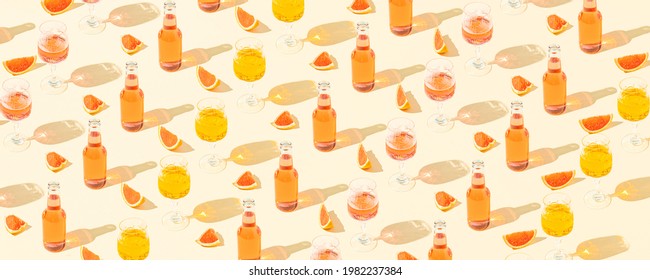 Summer creative cocktails pattern with bottles, glasses, slices of fresh grapefruit against a pastel beige background. Minimal vacation party concept.