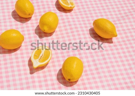 Summer creative layout with lemons on pastel pink plaid  background. 80s or 90s retro aesthetic idea. Minimal summer fruit idea.