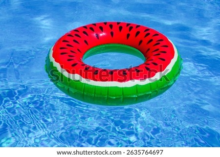 Summer day by the pool. Floating beach ball on pool water. Summer background. Inflatable toy. Summer vacation. Swimming pool with clear blue water. Summer paradise for leisure and rest.