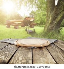 Summer Day In Garden With Grill And Desk Of Wood On Wooden Shabby Table 