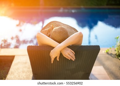 Summer day lifestyle woman relax and chill near luxury swimming pool sunbath at the beach resort outdoors the hotel.  Vacations and Summer Concept - Shutterstock ID 553256902
