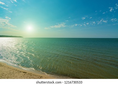 Summer deserted beach at sea, side view with the sun from above - Powered by Shutterstock