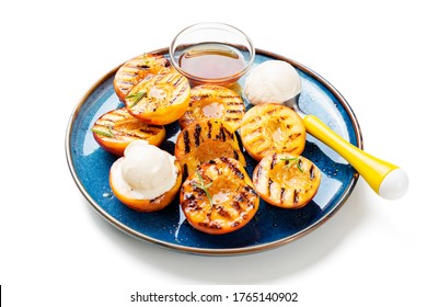 Summer dessert. Ripe grilled peaches with honey and ice cream isolated on white background