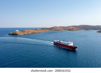 Summer destination Kea, Tzia island, Cyclades, Greece. A ferry boat approaching Korissia port aerial drone view. Red color passengers ship on calm sea and blue sky background. Summer holidays comcept