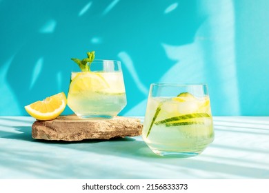 Summer detox refreshing drink or alcoholic cocktail with lemon slices and ice, garnished with a sprig of mint. Chilled water with lemon. Healthy drinks