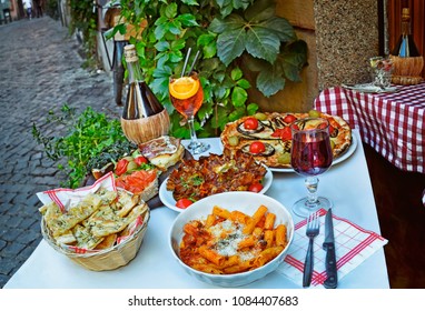 A Summer  Dinner .Unidentified People Eating Traditional Italian Food In Outdoor Restaurant In Trastevere District In Rome, Italy.   .Tasty And Authentic Italian Kitchen