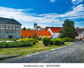 Summer in downtown of Nitra city, Slovakia. Old Town buildings with red roofs at distance, stone street pavement, slovak historical architecture on square under blue sky, famous tourist destination