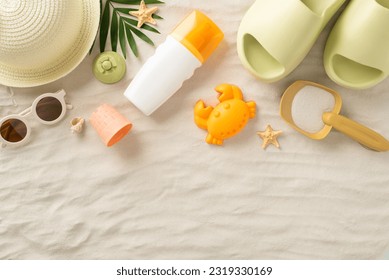 Summer escape with children concept. Top view photo of panama hat, kids' sand toys, palm leaves, seashells, sunscreen, flip-flops and sunglasses on an isolated sandy background with copyspace - Powered by Shutterstock