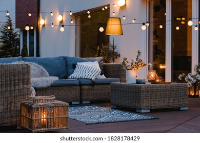 Noite de verão no pátio da bela casa suburbana com luzes no jardim