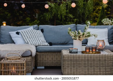 Summer Evening On The Terrace Of Beautiful Suburban House With Patio With Wicker Furniture And Lights