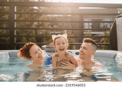 In summer, the family rests in the outdoor hot tub. - Shutterstock ID 2319546053