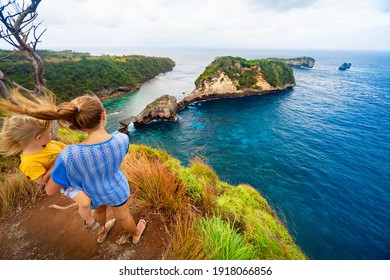 Summer Family Vacation. Young Mother, Baby Son Stand At High Cliff. Happy People Look At Amazing Sea View Of Tropical Atuh Beach. Nusa Penida Is Popular Travel Destination In Bali Island, Indonesia